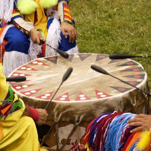 Indigenous Peoples around a drum at a Pow Wow